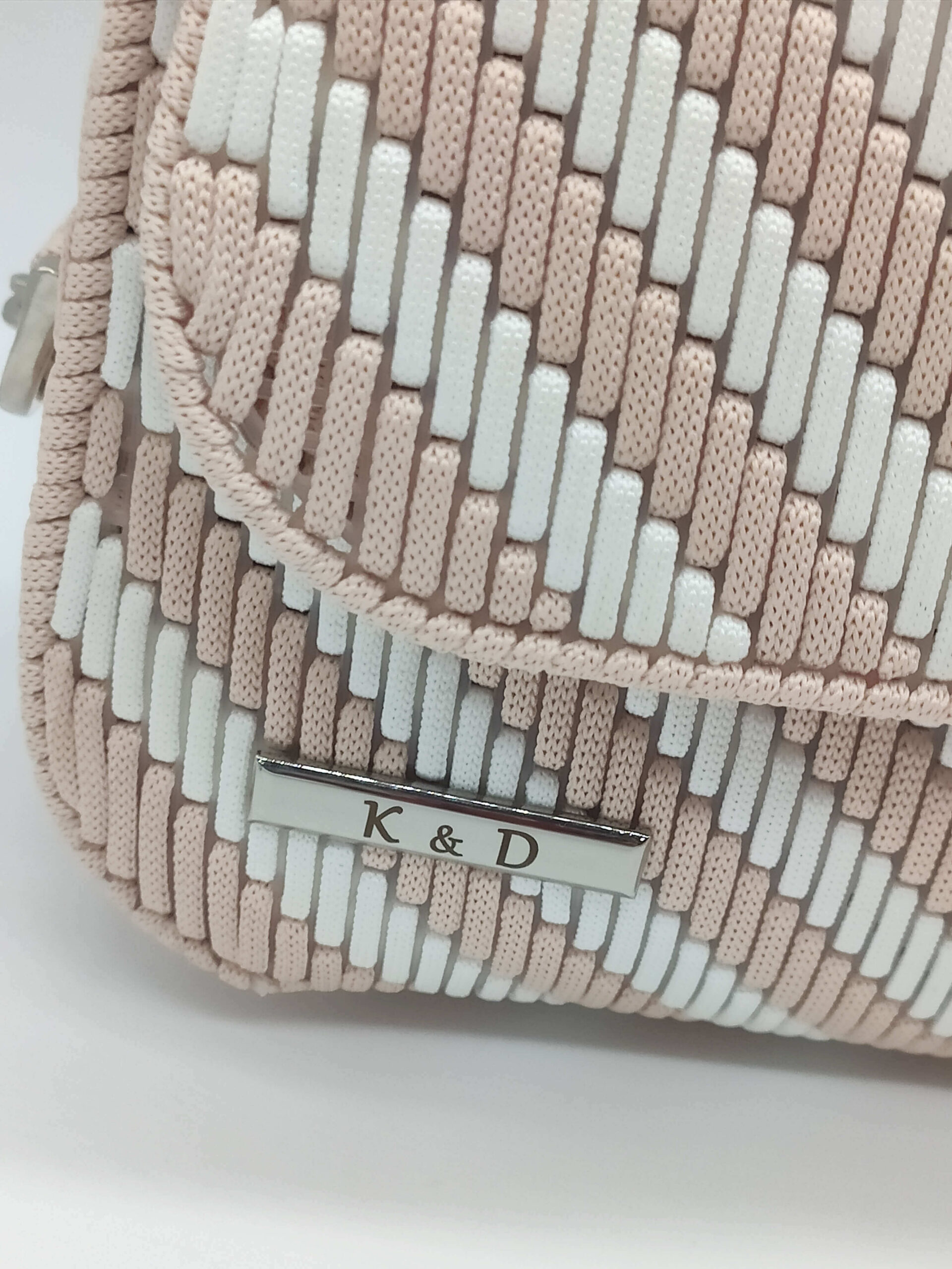 Torebka handmade Maja beżowo-biała na srebrnym łańcuszku. Zdjęcie z emblematem firmy
